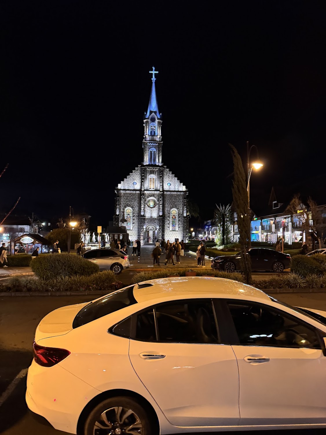 Igreja de pedra iluminada na praça central de Gramado à noite
